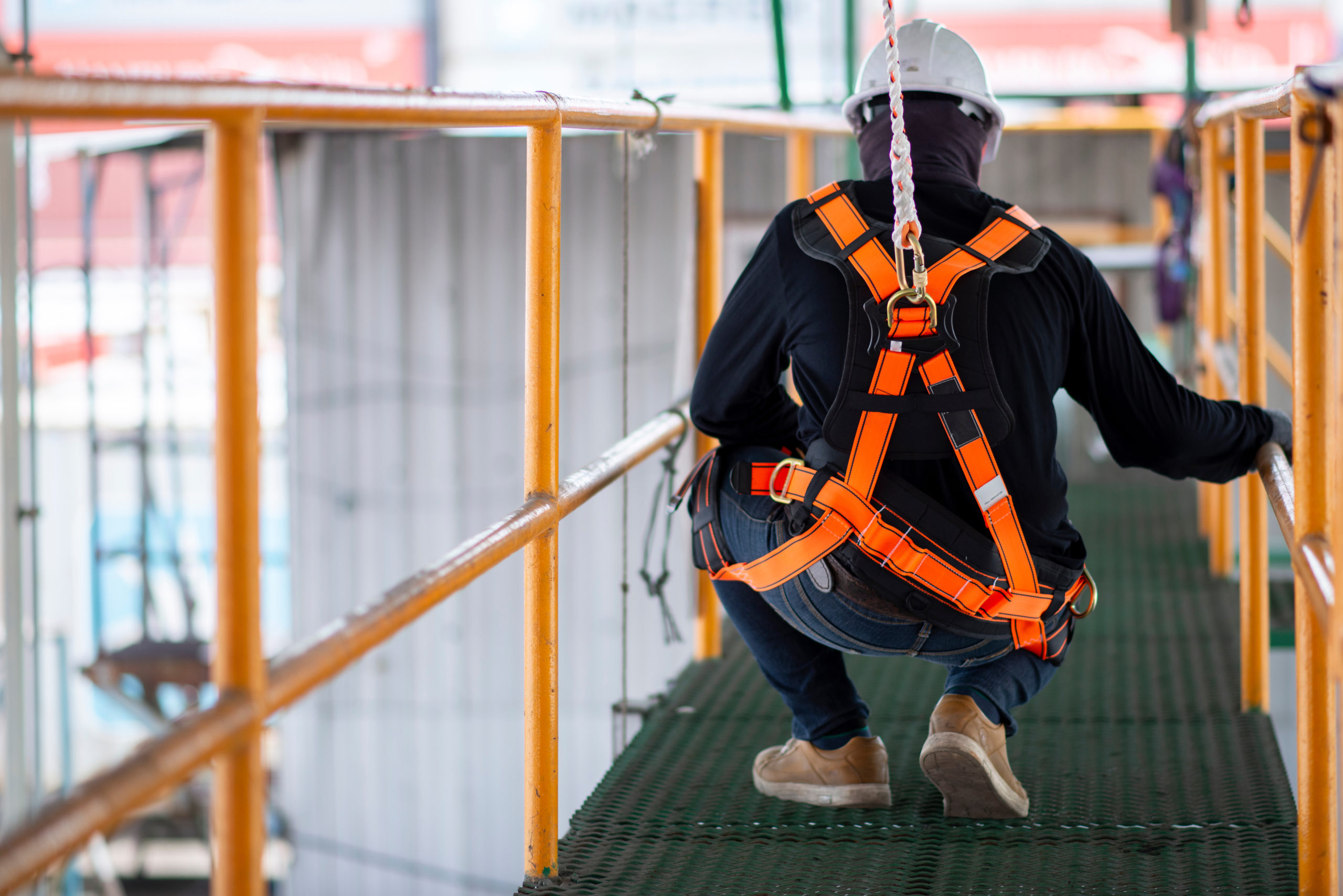 Construction worker wearing safety harness and safety line worki