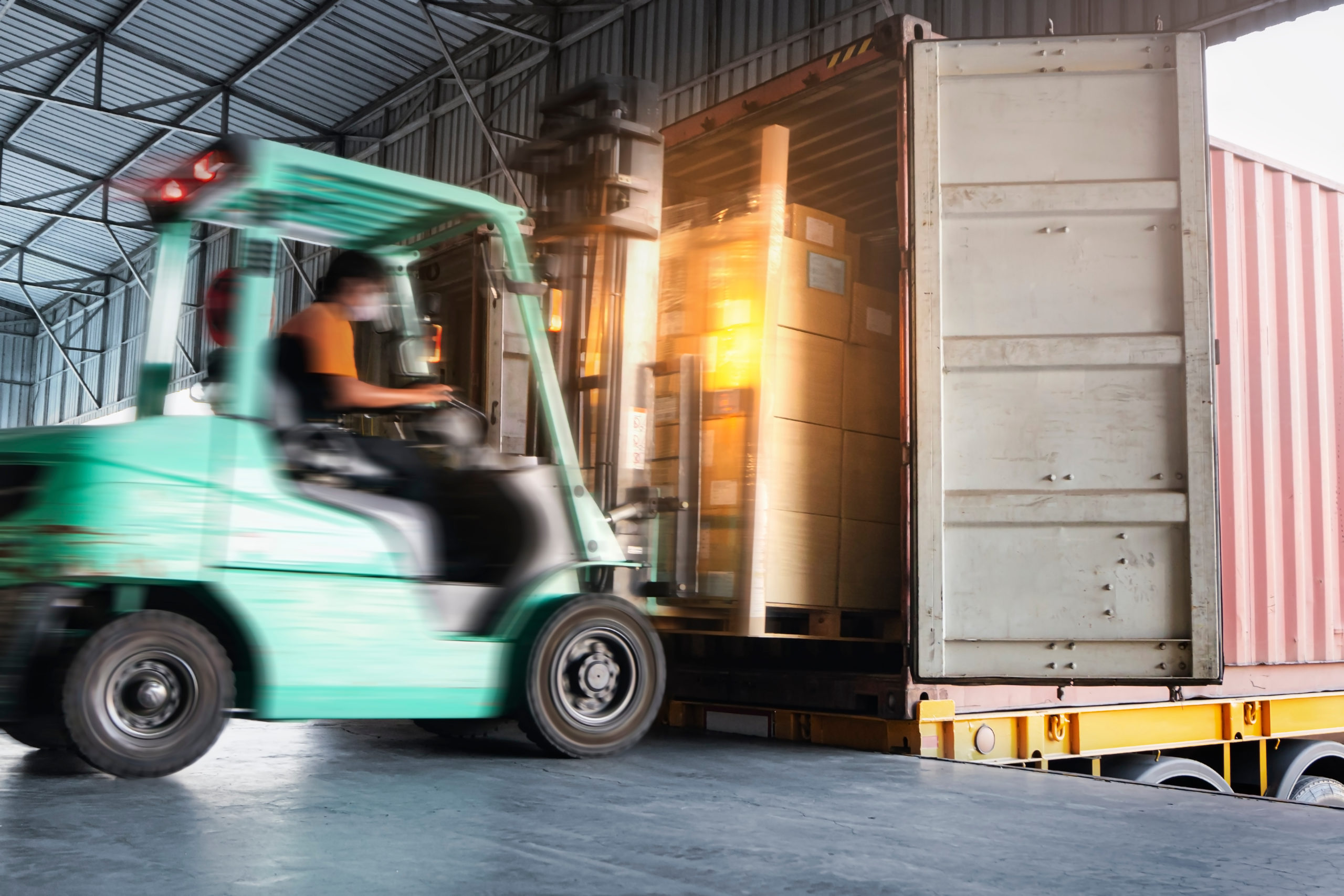 Forklift Tractor Loading Cargo Boxes at Dock Warehouse. Shipment
